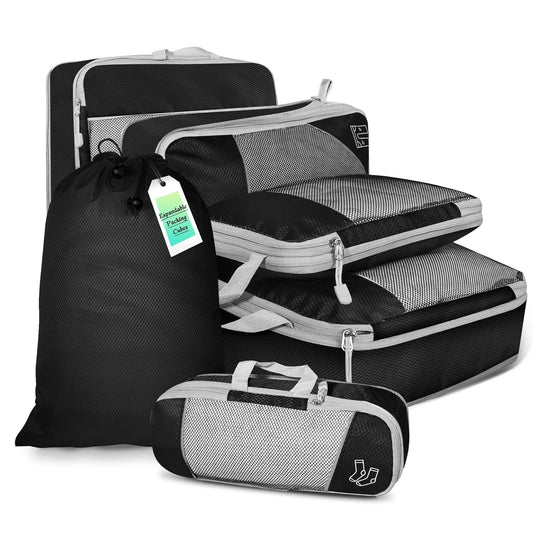 Set of black and gray packing cubes with a drawstring bag on a white background