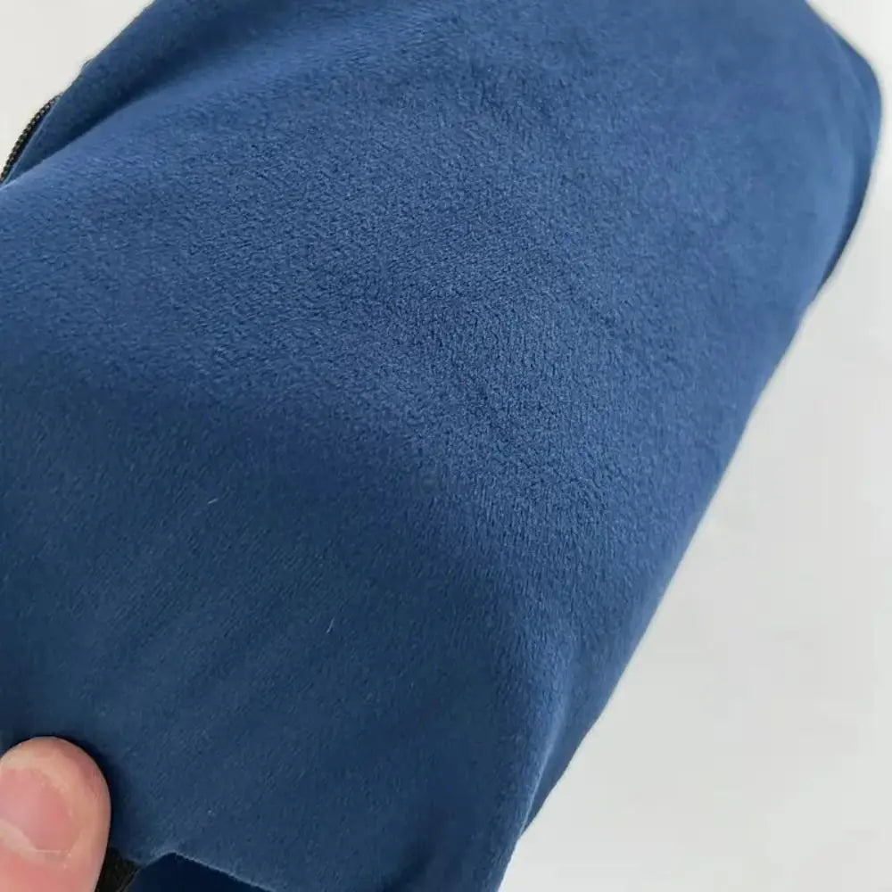Close-up of a blue textured fabric with a hand holding it on a light gray background