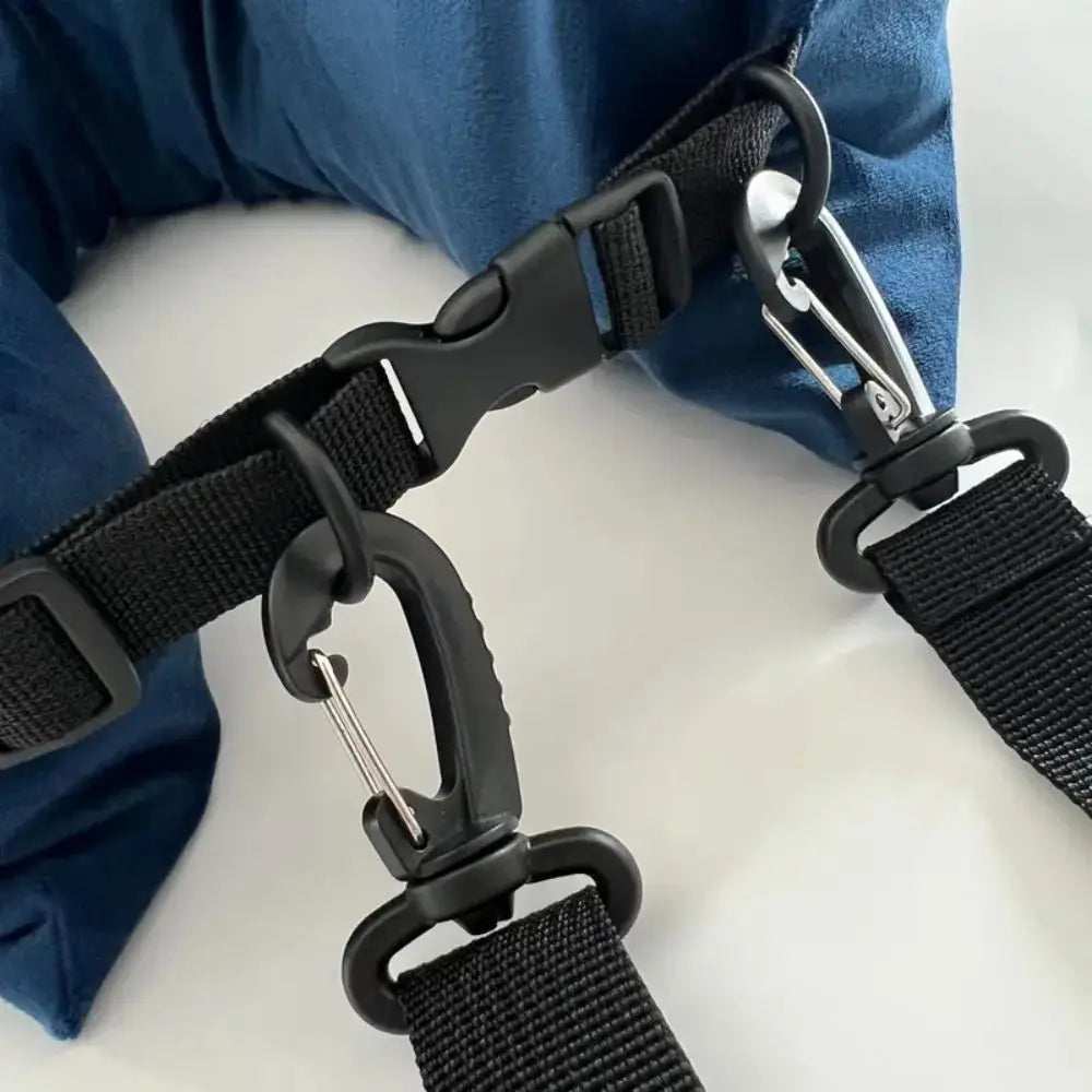Close-up of black straps with carabiners attached, against a blue fabric background.