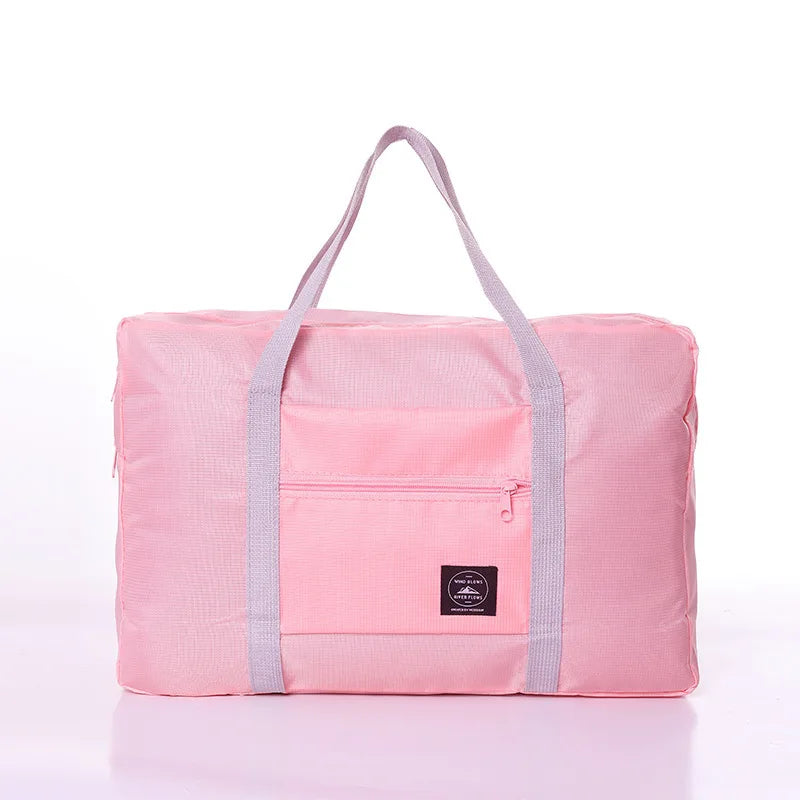 Pink duffel bag with gray straps on a white background