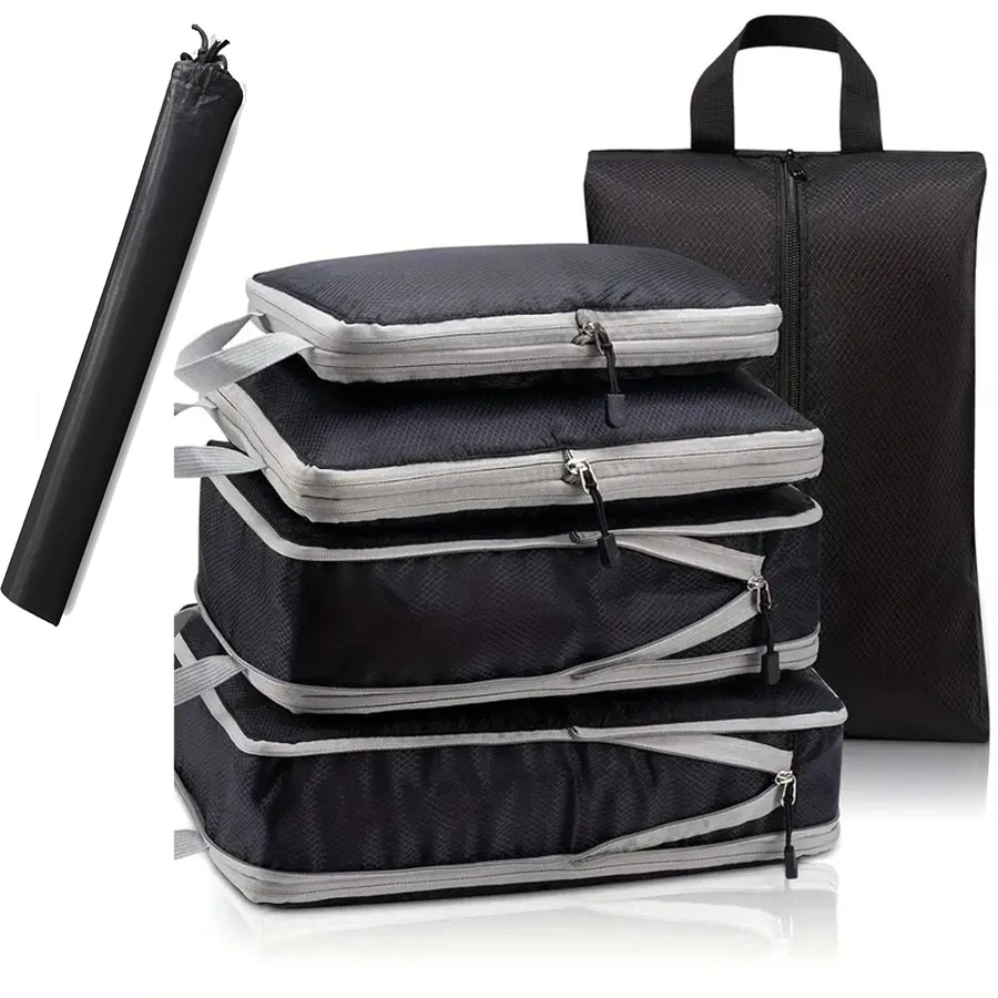 Set of black and gray packing cubes with a travel mat on a white background
