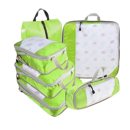 Set of green packing cubes with mesh compartments on a white background